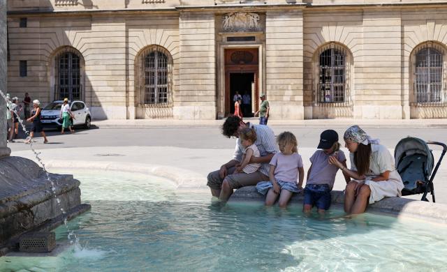 (260708) -- ARLES, July 8, 2026 (Xinhua) -- People cool off at a fountain in Arles, France, July 8, 2026. France has experienced high temperatures this summer. (Xinhua/Wu Huiwo)