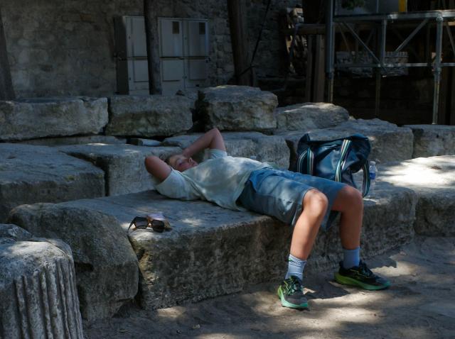 (260708) -- ARLES, July 8, 2026 (Xinhua) -- A boy rests inside the Roman theater in Arles, France, July 8, 2026. France has experienced high temperatures this summer. (Xinhua/Wu Huiwo)