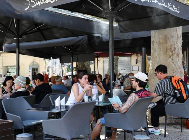 (260708) -- ARLES, July 8, 2026 (Xinhua) -- People dine on a restaurant terrace equipped with misting devices in Arles, France, July 8, 2026. France has experienced high temperatures this summer. (Xinhua/Wu Huiwo)