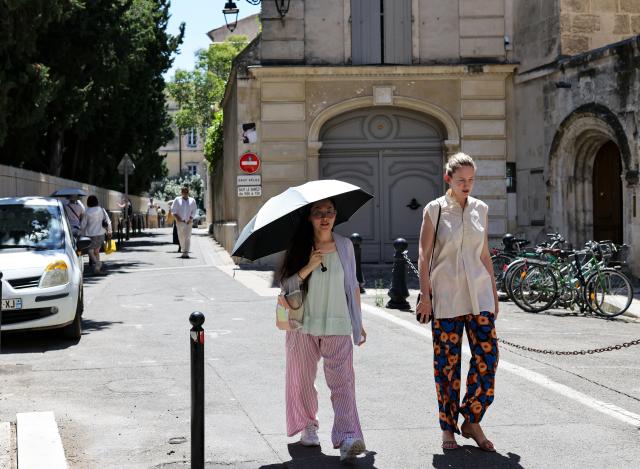 (260708) -- ARLES, July 8, 2026 (Xinhua) -- A woman walks with an umbrella in Arles, France, July 8, 2026. France has experienced high temperatures this summer. (Xinhua/Wu Huiwo)