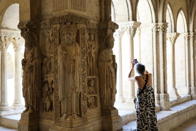 (260709) -- ARLES, July 9, 2026 (Xinhua) -- A woman takes photos in the cloister of the Church of St. Trophime in Arles, France, on July 8, 2026. (Xinhua/Wu Huiwo)