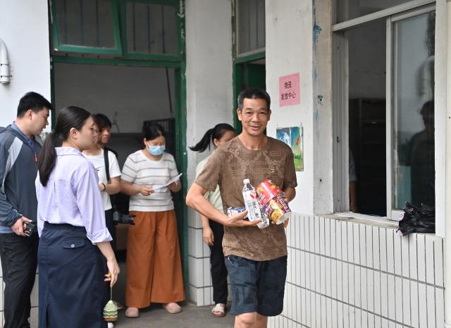 (260709) -- GUIGANG, July 9, 2026 (Xinhua) -- Flood-affected residents receive relief supplies at a temporary relocation site in Guigang City, south China's Guangxi Zhuang Autonomous Region, July 8, 2026.
  Guigang has set up 18 temporary relocation sites to shelter flood-affected residents. (Xinhua/Zhou Hua)