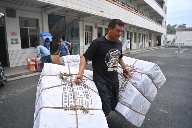 (260709) -- GUIGANG, July 9, 2026 (Xinhua) -- Flood-affected residents receive relief supplies at a temporary relocation site in Guigang City, south China's Guangxi Zhuang Autonomous Region, July 8, 2026.
  Guigang has set up 18 temporary relocation sites to shelter flood-affected residents. (Xinhua/Zhou Hua)