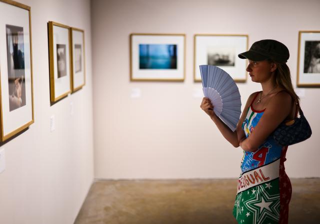 (260709) -- ARLES, July 9, 2026 (Xinhua) -- A woman views exhibits during an exhibition at the Rencontres d'Arles photography festival in Arles, France, July 8, 2026. The 57th Rencontres d'Arles photography festival lasts from July 6 to October 4. (Xinhua/Wu Huiwo)