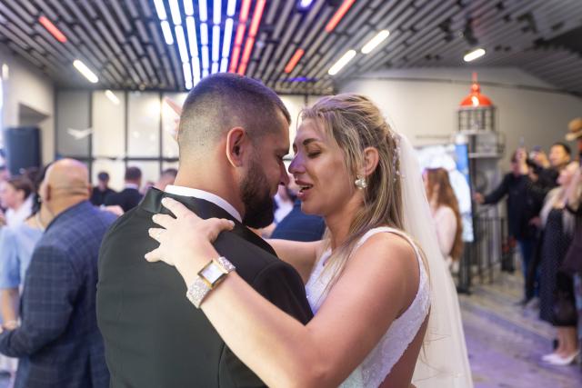 (260709) -- VLADIVOSTOK, July 9, 2026 (Xinhua) -- A couple dance during a group wedding in Vladivostok, Russia, July 8, 2026. Vladivostok held a "Wedding Festival" on Wednesday, with 11 couples registering their marriages and participating in a group wedding. (Photo by Andrey Matveenko/Xinhua)