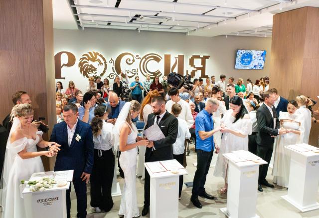 (260709) -- VLADIVOSTOK, July 9, 2026 (Xinhua) -- Newlyweds exchange rings during a group wedding in Vladivostok, Russia, July 8, 2026. Vladivostok held a "Wedding Festival" on Wednesday, with 11 couples registering their marriages and participating in a group wedding. (Photo by Andrey Matveenko/Xinhua)