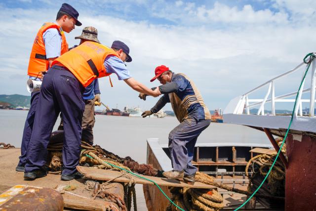 (260709) -- HANGZHOU, July 9, 2026 (Xinhua) -- Police officers help fishermen evacuate from a fishing boat at a port in Daishan County, Zhoushan City, east China's Zhejiang Province, July 9, 2026. China's State Flood Control and Drought Relief Headquarters on Wednesday activated a Level-IV emergency response for flood control and typhoon prevention in the provinces of Zhejiang and Fujian, the Ministry of Emergency Management said.
   Super Typhoon Bavi is forecast to move westward before turning northwestward at a speed of around 15 to 20 km per hour, and may make landfall along the coast between Fuqing in Fujian Province and Wenling in Zhejiang Province on Saturday night, as either a strong typhoon or a typhoon. (Photo by Xing Shoumiao/Xinhua)