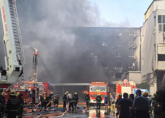 (260709) -- JINJIANG, July 9, 2026 (Xinhua) -- Firefighters work after a fire broke out at a footwear factory in Jiangtou Village, Chendai Township of Jinjiang City, southeast China's Fujian Province, on July 9, 2026. A fire hit a footwear factory in Fujian, with several people reported trapped or missing, local authorities said Thursday. Firefighting was still underway, with multiple fire trucks and ambulances on standby at the scene. (Xinhua/Zheng Liang)
