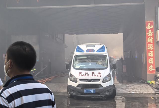 (260709) -- JINJIANG, July 9, 2026 (Xinhua) -- An ambulance is on standby at the scene of a fire at a footwear factory in Jiangtou Village, Chendai Township of Jinjiang City, southeast China's Fujian Province, on July 9, 2026. A fire hit a footwear factory in Fujian, with several people reported trapped or missing, local authorities said Thursday. Firefighting was still underway, with multiple fire trucks and ambulances on standby at the scene. (Xinhua/Zheng Liang)