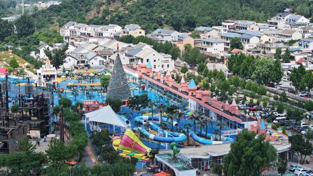 (260709) -- TIANJIN, July 9, 2026 (Xinhua) -- A drone photo taken on July 8, 2026 shows a view of an amusement park in Xiaying Town of Jizhou District, north China's Tianjin. Xiaying Town in Jizhou District of Tianjin ushered in a travel boom as the summer vacation season began in China. In recent years, the town, taking advantages of its unique mountain, forest and water resources, has built a number of distinctive tourist attractions to meet people's various travelling demands. (Xinhua/Li Ran)