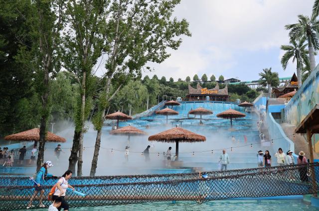 (260709) -- TIANJIN, July 9, 2026 (Xinhua) -- People enjoy their leisure time at a lake in Xiaying Town of Jizhou District, north China's Tianjin, July 8, 2026. Xiaying Town in Jizhou District of Tianjin ushered in a travel boom as the summer vacation season began in China. In recent years, the town, taking advantages of its unique mountain, forest and water resources, has built a number of distinctive tourist attractions to meet people's various travelling demands. (Xinhua/Li Ran)