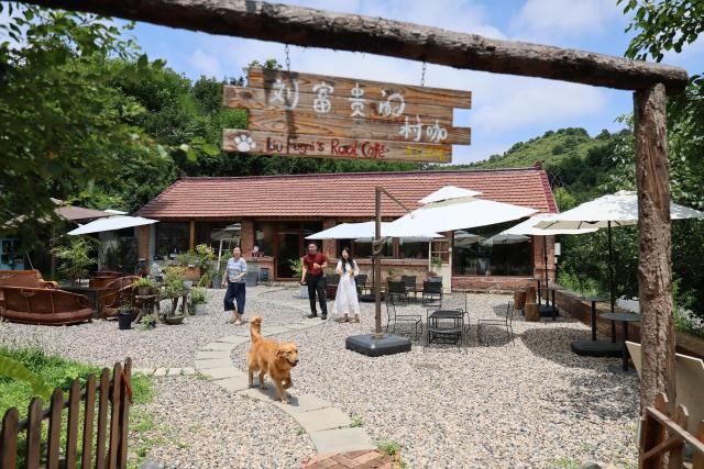 (260709) -- TIANJIN, July 9, 2026 (Xinhua) -- People have fun at a cafe in Xiaying Town of Jizhou District, north China's Tianjin, July 8, 2026. Xiaying Town in Jizhou District of Tianjin ushered in a travel boom as the summer vacation season began in China. In recent years, the town, taking advantages of its unique mountain, forest and water resources, has built a number of distinctive tourist attractions to meet people's various travelling demands. (Xinhua/Li Ran)