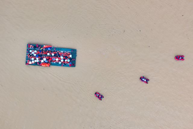 (260709) -- NANNING, July 9, 2026 (Xinhua) -- An aerial drone photo shows rescuers evacuating trapped students on a powered pontoon bridge in Guigang City, south China's Guangxi Zhuang Autonomous Region, July 9, 2026. Recent extreme rainstorms triggered by Typhoon Maysak, the 10th typhoon of the year, have caused severe flooding in parts of Guangxi in the Pearl River basin.
  Guangxi is continuing its search and rescue operations for missing persons, enhancing resettlement services for affected residents and advancing post-disaster reconstruction. (Xinhua/Zhou Hua)