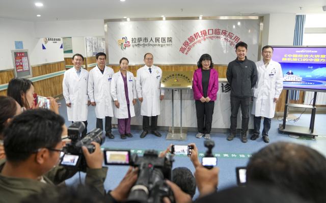 (260709) -- LHASA, July 9, 2026 (Xinhua) -- Guests pose for photos during the plateau brain-computer interface (BCI) clinical application center inauguration ceremony at Lhasa People's Hospital in Lhasa, southwest China's Xizang Autonomous Region, July 9, 2026. The first plateau BCI clinical application center in Xizang was officially inaugurated at Lhasa People's Hospital on Thursday, marking a significant step for the region in leveraging cutting-edge technology to address intractable neurological diseases.
 As a transformative human-computer interaction solution, BCI technology has shown great potential in the neurological rehabilitation field.
 This year, a medical assistance team from Beijing Tiantan Hospital to Xizang introduced the BCI technology to the region, which will promote the implementation of cutting-edge medical technologies to benefit people in Xizang. (Xinhua/Jigme Dorje)