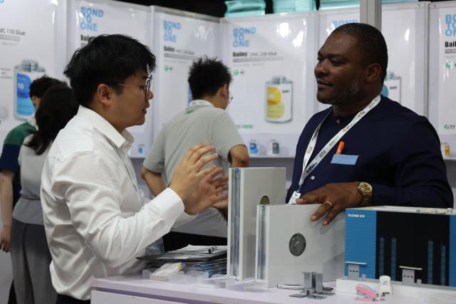 (260709) -- ACCRA, July 9, 2026 (Xinhua) -- A Chinese exhibitor (L) introduces his equipment to a visitor at the three-day Ghana Investment and Trade Week and Africa Build Show in Accra, Ghana, July 8, 2026. TO GO WITH "Roundup: Chinese businesses explore opportunities at Ghana Investment and Trade Week" (Photo by Seth/Xinhua)