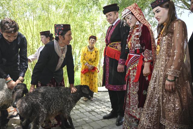 (260709) -- TAXKORGAN, July 9, 2026 (Xinhua) -- Relatives of the bride present several sheep to the newlyweds to congratulate them on their wedding in Taxkorgan Tajik Autonomous County, northwest China's Xinjiang Uygur Autonomous Region, June 30, 2026. This summer, happiness filled the air around the home of herdsman Duri Jarman. His youngest son Nurkerim tied the knot with his beloved woman. Weddings of the Tajik ethnic group usually last three days. Inscribed on the national intangible cultural heritage list in 2008, the wedding customs of the Tajik ethnic group maintain unique traditions and are always described as festivals of music, dance and food to showcase the resplendent newlyweds and their propitious marriage.
  In Aimin Village, this wedding also serves as a vivid epitome of the eight-year transformative leap brought by the poverty alleviation relocation program.
  In the winter of 2018, Jarman and his family benefited from the relocation policy for poverty alleviation and settled in Aimin Village. They gradually adapted to the changes, enjoying a new life different from that of their ancestors. Jarman ran a small grocery store with Nurkerim, while his eldest and second sons both landed stable new jobs. Nurkerim also bought a pickup truck to run a transport business. It was this business that brought him together with his wife. For this family, the relocation is not only an opportunity for development, but also a path leading to happiness.
  Over the past eight years, Jarman has expanded his courtyard and planted saplings year after year. His small yard, where not a single tree used to grow, is now shaded by lush, thriving woods. As relocation sites of the poverty alleviation relocation program, Aimin Village and neighboring Fumin Village are now home to 321 households, with at least one person employed per household on average. (Xinhua/Hu Huhu)