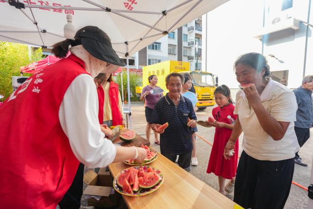 (260709) -- YIBIN, July 9, 2026 (Xinhua) -- Volunteers deliver watermelons at a temporary resettlement site for quake-affected people in Qunle Village of Gaoxian County, Yibin City, southwest China's Sichuan Province, July 9, 2026. A 5.0-magnitude earthquake jolted Gaoxian County, Yibin City, at 10:08 a.m. on Wednesday (Beijing Time), according to the China Earthquake Networks Center (CENC). Local authorities are making sustained efforts to ensure sound resettlement of quake-affected people. (Xinhua/Wang Xi)
