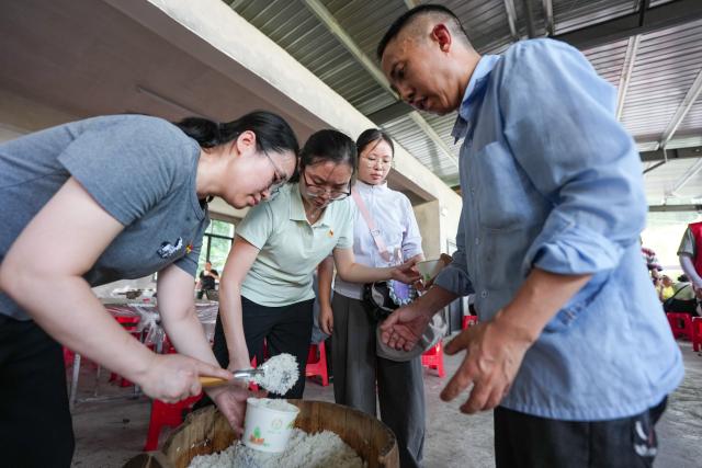 (260709) -- YIBIN, July 9, 2026 (Xinhua) -- Staff provide food for a man at a temporary resettlement site for quake-affected people in Qunle Village of Gaoxian County, Yibin City, southwest China's Sichuan Province, July 9, 2026. A 5.0-magnitude earthquake jolted Gaoxian County, Yibin City, at 10:08 a.m. on Wednesday (Beijing Time), according to the China Earthquake Networks Center (CENC). Local authorities are making sustained efforts to ensure sound resettlement of quake-affected people. (Xinhua/Wang Xi)