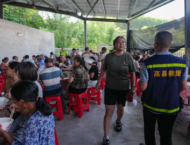 (260709) -- YIBIN, July 9, 2026 (Xinhua) -- People have meals at a temporary resettlement site for quake-affected people in Qunle Village of Gaoxian County, Yibin City, southwest China's Sichuan Province, July 9, 2026. A 5.0-magnitude earthquake jolted Gaoxian County, Yibin City, at 10:08 a.m. on Wednesday (Beijing Time), according to the China Earthquake Networks Center (CENC). Local authorities are making sustained efforts to ensure sound resettlement of quake-affected people. (Xinhua/Wang Xi)