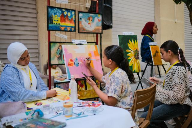 (260709) -- CAIRO, July 9, 2026 (Xinhua) -- Young artists create artworks in downtown Cairo, Egypt, July 9, 2026. Egypt's government recently launched the "Street of Art" initiative, aiming to transform the streets and squares of the capital, Cairo, into open-air cultural spaces. Every Thursday through Saturday evening, the public can enjoy free cultural activities such as poetry readings, musical performances, and visual art exhibitions, attracting active participation from both citizens and tourists. (Xinhua/Xin Mengchen)