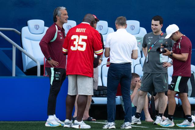 (260710) -- KANSAS CITY, July 10, 2026 (Xinhua) -- Switzerland's head coach Murat Yakin (1st L) is seen with former Kansas City Chiefs player Christian Okoye (2nd L) during a training session ahead of their 2026 FIFA World Cup quarterfinal match against Argentina in Kansas City, the United States, July 9, 2026. (Xinhua/Xiao Yijiu)