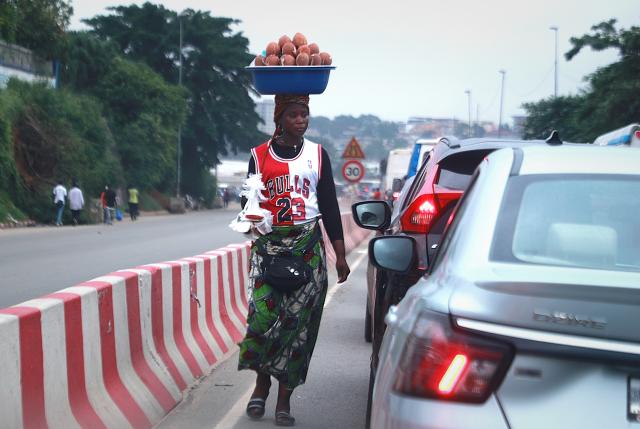 (260710) -- ABIDJAN, July 10, 2026 (Xinhua) -- A woman sells coconuts among vehicles on a road in Abidjan, Cote d'Ivoire, on July 9, 2026. (Photo by Yvan Sonh/Xinhua)
