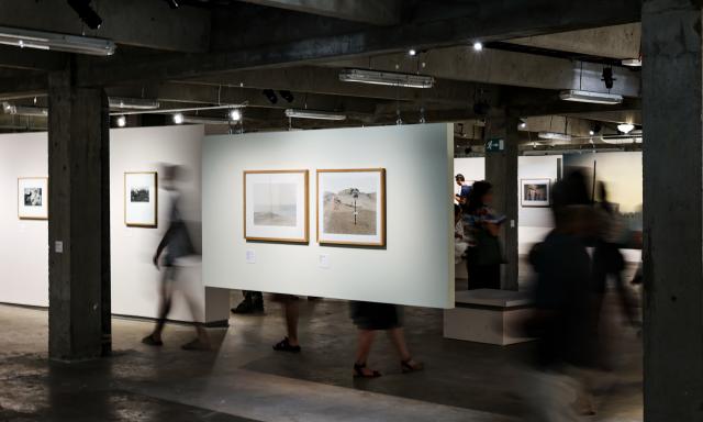 (260710) -- BEIJING, July 10, 2026 (Xinhua) -- People view exhibits during an exhibition at the Rencontres d'Arles photography festival in Arles, France, July 8, 2026. The 57th Rencontres d'Arles photography festival lasts from July 6 to October 4. (Xinhua/Wu Huiwo)