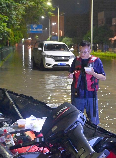 (260710) -- GUIGANG, July 10, 2026 (Xinhua) -- A rescuer has a meal during a short break in Guigang, south China's Guangxi Zhuang Autonomous Region, July 9, 2026.
  Guigang has suffered severe flooding due to torrential rains brought by Typhoon Maysak and upstream inflows. Local authorities have mobilized rescue forces to work around the clock, making every effort to ensure basic living needs for stranded residents. (Xinhua/Zhou Hua)