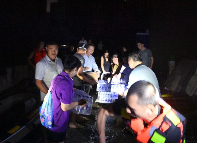(260710) -- GUIGANG, July 10, 2026 (Xinhua) -- Rescuers deliver supplies to stranded residents in Guigang, south China's Guangxi Zhuang Autonomous Region, July 9, 2026.
  Guigang has suffered severe flooding due to torrential rains brought by Typhoon Maysak and upstream inflows. Local authorities have mobilized rescue forces to work around the clock, making every effort to ensure basic living needs for stranded residents. (Xinhua/Zhou Hua)