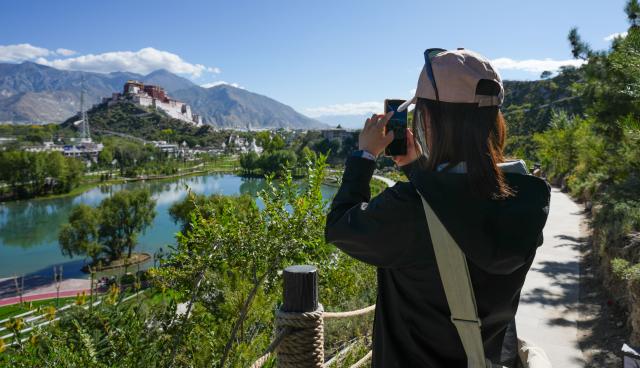(260710) -- LHASA, July 10, 2026 (Xinhua) -- A tourist takes photos at the foot of Yaowang Mountain in Lhasa, southwest China's Xizang Autonomous Region, Sept. 25, 2025.
  TO GO WITH "China Focus: Beyond pilgrimage, Lhasa looks to a broader future on 'roof of the world'" (Xinhua/Jigme Dorje)