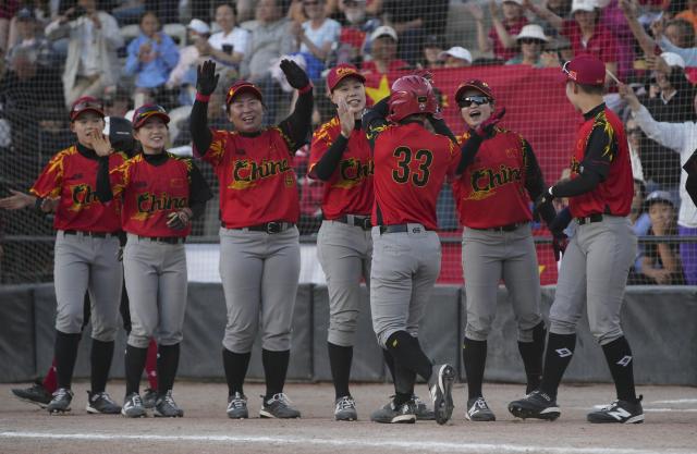 (260710) -- SURREY, July 10, 2026 (Xinhua) -- Players of China celebrate after Yang Huiqi (front) hits a home run during a round-robin match between China and Canada at the 2026 Canada Cup International Softball Championship in Surrey, British Columbia, Canada, July 9, 2026. (Photo by Liang Sen/Xinhua)