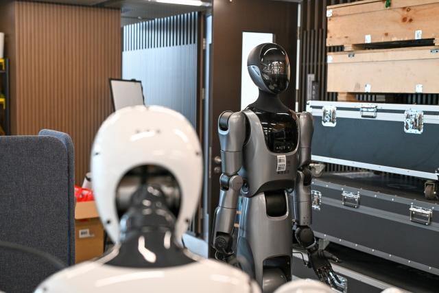 (260710) -- SHANGHAI, July 10, 2026 (Xinhua) -- Humanoid robots awaiting adjustment are pictured at Shanghai Innovation Institute in Xuhui District of east China's Shanghai, July 9, 2026. The institute is working with 31 institutions of higher learning to cultivate top-tier talents for artificial intelligence (AI). It boasts over 80 full-time mentors now, and has enrolled more than 800 doctoral students in 45 majors. The mentors and their students are collaborating in cutting-edge areas such as contextual AI, cognitive AI, and embodied AI. (Xinhua/Chen Shuo)