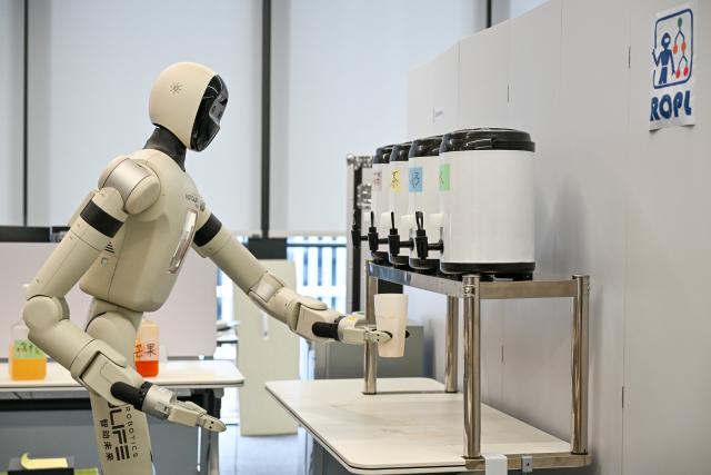 (260710) -- SHANGHAI, July 10, 2026 (Xinhua) -- A humanoid robot prepares milk tea at Shanghai Innovation Institute in Xuhui District of east China's Shanghai, July 9, 2026. The institute is working with 31 institutions of higher learning to cultivate top-tier talents for artificial intelligence (AI). It boasts over 80 full-time mentors now, and has enrolled more than 800 doctoral students in 45 majors. The mentors and their students are collaborating in cutting-edge areas such as contextual AI, cognitive AI, and embodied AI. (Xinhua/Chen Shuo)