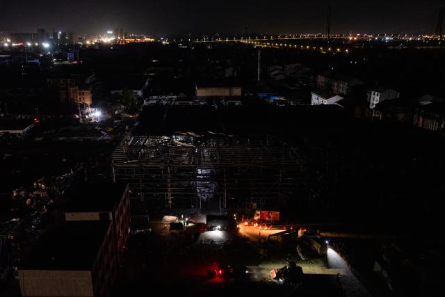 (260710) -- HUANGGANG, July 10, 2026 (Xinhua) -- An aerial drone photo taken on July 9, 2026 shows rescuers transfering supplies at a tornado-affected logistics park in Huangzhou District of Huanggang, central China's Hubei Province. A large batch of essential supplies including rice, flour, grains, edible oil, and convenience foods had been put at risk of water damage inside a logistics park of Huanggang since a tornado hit the city on Monday. Rescuers worked around the clock and successfully relocated the supplies to designated storage sites after more than 10 hours of effort from Thursday afternoon to Friday morning. (Xinhua/Wu Zhizun)