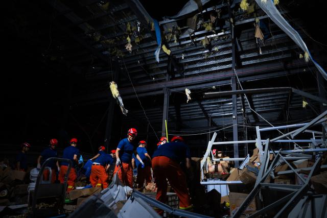 (260710) -- HUANGGANG, July 10, 2026 (Xinhua) -- Rescuers transfer supplies at a tornado-affected logistics park in Huangzhou District of Huanggang, central China's Hubei Province, July 9, 2026. A large batch of essential supplies including rice, flour, grains, edible oil, and convenience foods had been put at risk of water damage inside a logistics park of Huanggang since a tornado hit the city on Monday. Rescuers worked around the clock and successfully relocated the supplies to designated storage sites after more than 10 hours of effort from Thursday afternoon to Friday morning. (Xinhua/Wu Zhizun)