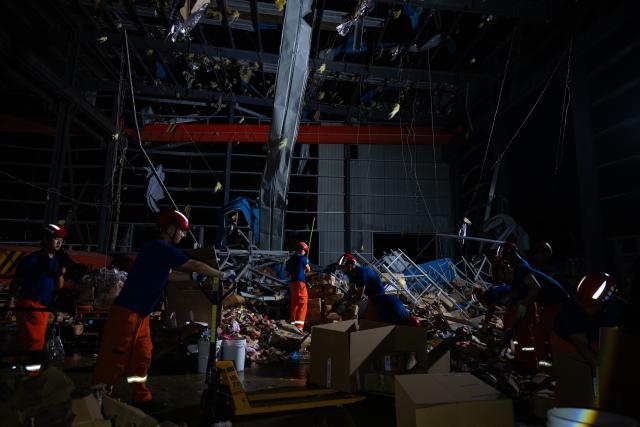 (260710) -- HUANGGANG, July 10, 2026 (Xinhua) -- Rescuers transfer supplies at a tornado-affected logistics park in Huangzhou District of Huanggang, central China's Hubei Province, July 9, 2026. A large batch of essential supplies including rice, flour, grains, edible oil, and convenience foods had been put at risk of water damage inside a logistics park of Huanggang since a tornado hit the city on Monday. Rescuers worked around the clock and successfully relocated the supplies to designated storage sites after more than 10 hours of effort from Thursday afternoon to Friday morning. (Xinhua/Wu Zhizun)
