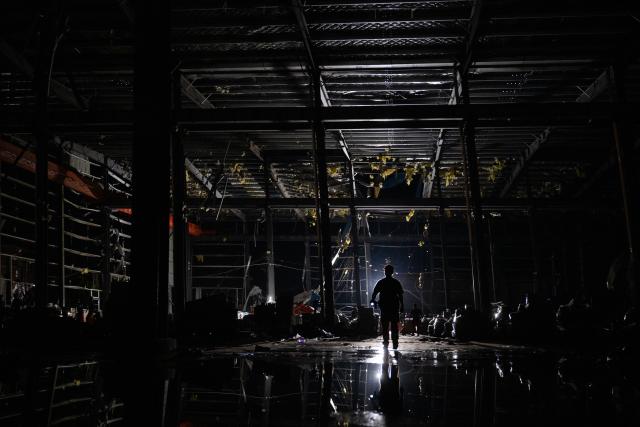 (260710) -- HUANGGANG, July 10, 2026 (Xinhua) -- A rescuer works at a tornado-affected logistics park in Huangzhou District of Huanggang, central China's Hubei Province, July 9, 2026. A large batch of essential supplies including rice, flour, grains, edible oil, and convenience foods had been put at risk of water damage inside a logistics park of Huanggang since a tornado hit the city on Monday. Rescuers worked around the clock and successfully relocated the supplies to designated storage sites after more than 10 hours of effort from Thursday afternoon to Friday morning. (Xinhua/Wu Zhizun)