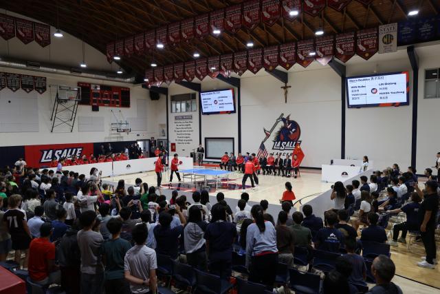 (260710) -- LOS ANGELES, July 10, 2026 (Xinhua) -- Members of China's national table tennis team hold a demonstration match at La Salle College Preparatory in Los Angeles, the United States, July 6, 2026.
  TO GO WITH "Feature: Chinese table tennis team turns school gym into stage for friendship" (Photo by Zeng Hui/Xinhua)