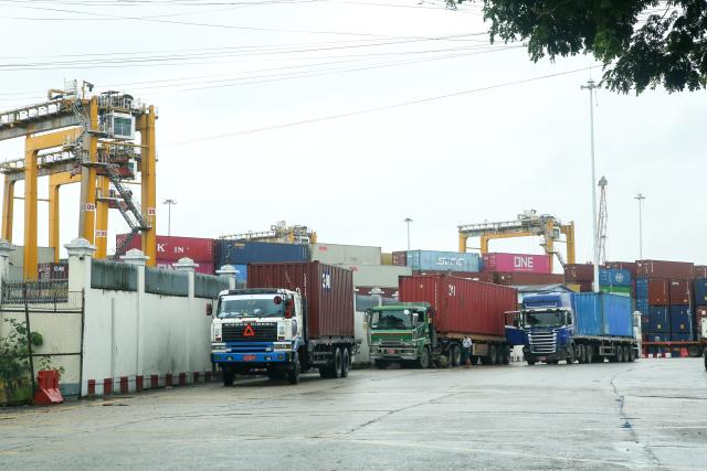(260710) -- YANGON, July 10, 2026 (Xinhua) -- Trucks carrying containers queue near a port in Yangon, Myanmar, July 10, 2026. Myanmar exported over 1 million tons of beans and pulses, maize and sesame seeds in the first three months of the current fiscal year 2026-27, which began in April, earning over 538 million U.S. dollars, according to the Myanmar Pulses, Beans, Maize and Sesame Seeds Merchants Association on Friday. (Xinhua/Myo Kyaw Soe)