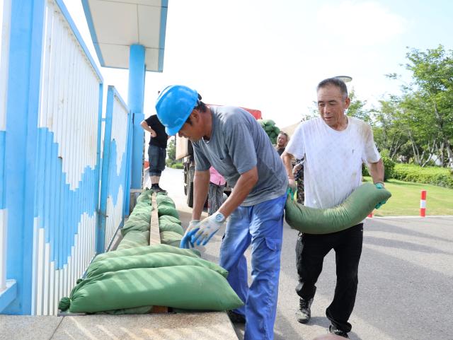 (260710) -- BEIJING, July 10, 2026 (Xinhua) -- Staff members stack sandbags at Shenjiamen Port in Zhoushan, east China's Zhejiang Province, July 10, 2026. China's national observatory on Friday renewed an orange alert for Typhoon Bavi, the ninth typhoon of 2026, which is expected to bring gales and heavy rain to eastern China. Affected regions are on high alert, with all prevention and response measures fully implemented to safeguard people's lives and property. (Photo by Xing Shoumiao/Xinhua)