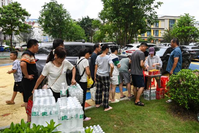 (260710) -- NANNING, July 10, 2026 (Xinhua) -- Residents line up to receive relief supplies at a community in Guigang, south China's Guangxi Zhuang Autonomous Region, July 10, 2026. The local authorities beef up restoration efforts after torrential rains caused by Typhoon Maysak. (Xinhua/Cao Yiming)