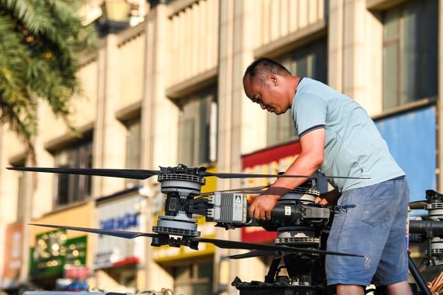 (260710) -- NANNING, July 10, 2026 (Xinhua) -- A man retreats his drone after a supply deployment in Guigang, south China's Guangxi Zhuang Autonomous Region, July 10, 2026. The local authorities beef up restoration efforts after torrential rains caused by Typhoon Maysak. (Xinhua/Cao Yiming)