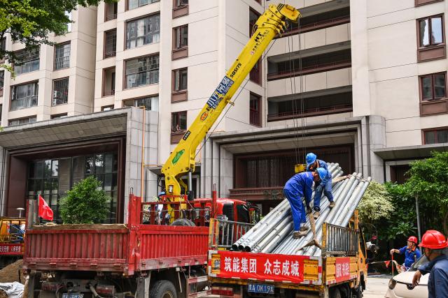 (260710) -- NANNING, July 10, 2026 (Xinhua) -- Power utility workers work at a community in Guigang, south China's Guangxi Zhuang Autonomous Region, July 10, 2026. The local authorities beef up restoration efforts after torrential rains caused by Typhoon Maysak. (Xinhua/Cao Yiming)