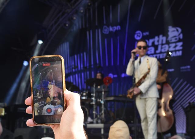 (260710) -- ROTTERDAM, July 10, 2026 (Xinhua) -- An audience records a jazz band's performance during opening day of the 50th North Sea Jazz Festival in Rotterdam, the Netherlands on July 10, 2026. (Xinhua/Shao Haijun)