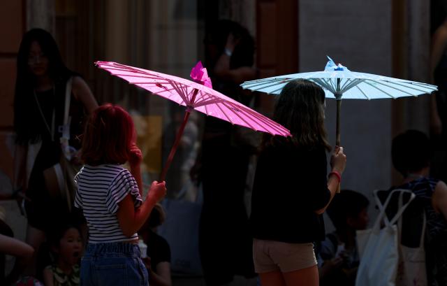 (260711) -- BEIJING, July 11, 2026 (Xinhua) -- Tourists shield themselves from the sun with umbrellas near Piazza di Spagna in Rome, Italy, July 10, 2026.
  A new round of heatwave is underway around Italy, with the average temperature consistently around 35 degrees Celsius and peaks exceeding 40 degrees Celsius. (Xinhua/Wang Kaiyan)