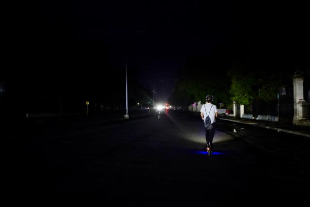 (260711) -- HAVANA, July 11, 2026 (Xinhua) -- A man rides an electric scooter on a street during a blackout in Havana, Cuba, July 10, 2026. Cuba was hit by another nationwide blackout on Friday, as the country's power system completely collapsed at 4:30 p.m. local time, according to the National Electric Union. (Xinhua/Jiang Biao)