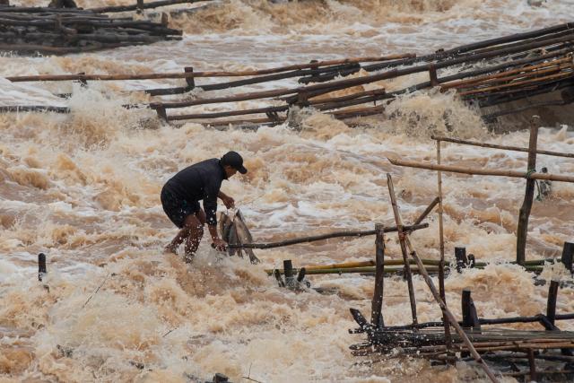 (260711) -- CHAMPASAK, July 11, 2026 (Xinhua) -- A fisherman catches fish in the Mekong River in Champasak Province, Laos, July 10, 2026. Champasak Province in southern Laos is home to the final section of the Mekong River running through the country, and well noted for a diverse array of river fish and rich aquatic resources. Many locals rely on fishing for their livelihood. (Photo by Kaikeo Saiyasane/Xinhua)