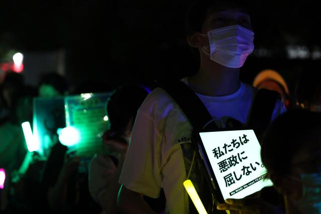 (260711) -- TOKYO, July 11, 2026 (Xinhua) -- People holding signs attend a protest rally in front of the National Diet Building in Tokyo, Japan, July 10, 2026. A large number of Japanese citizens gathered in front of the National Diet Building in Tokyo on Friday evening to protest a series of dangerous policies and bills recently promoted by the government of Prime Minister Sanae Takaichi. (Xinhua/Yue Chenxing)