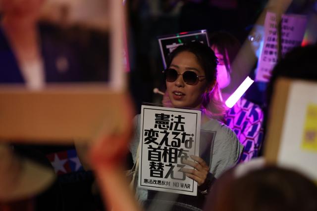 (260711) -- TOKYO, July 11, 2026 (Xinhua) -- A woman holding a sign attends a protest rally in front of the National Diet Building in Tokyo, Japan, July 10, 2026. A large number of Japanese citizens gathered in front of the National Diet Building in Tokyo on Friday evening to protest a series of dangerous policies and bills recently promoted by the government of Prime Minister Sanae Takaichi. (Xinhua/Yue Chenxing)