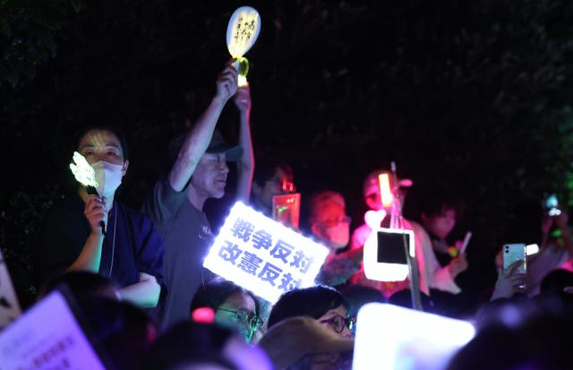 (260711) -- TOKYO, July 11, 2026 (Xinhua) -- People holding signs attend a protest rally in front of the National Diet Building in Tokyo, Japan, July 10, 2026. A large number of Japanese citizens gathered in front of the National Diet Building in Tokyo on Friday evening to protest a series of dangerous policies and bills recently promoted by the government of Prime Minister Sanae Takaichi. (Xinhua/Yue Chenxing)